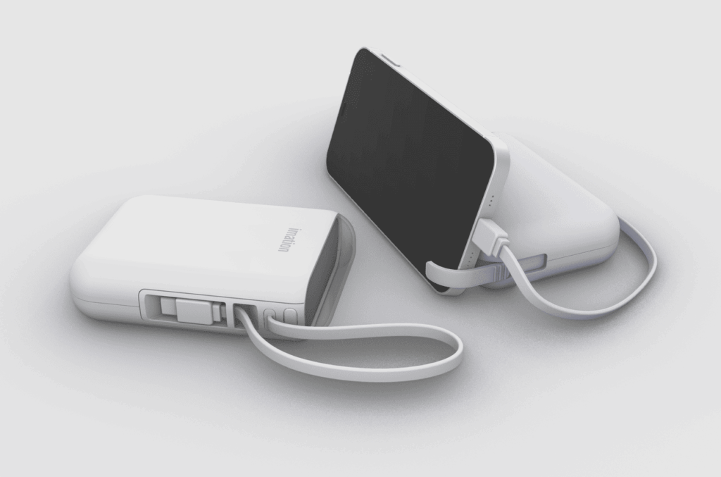 두 개의 휴대용 보조 배터리가 나란히 놓여 있습니다. 하나는 흰색이며 'imation' 로고가 있고, 다른 하나는 연보라색이며 스마트폰에 연결되어 충전 중인 모습입니다. 두 보조 배터리 모두 흰색 휴대용 스트랩이 달려 있습니다.